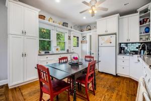 a kitchen with white cabinets and a table and chairs at Hydrangea House in New Buffalo