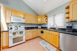 a kitchen with wooden cabinets and white appliances at Tranquil Woods in Ocean Pines
