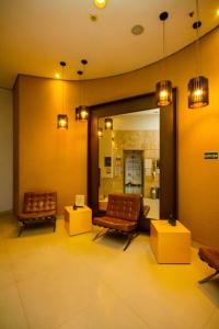 a waiting room with two chairs and a mirror at Flat Executivo GRU Airport in Guarulhos +53 photos