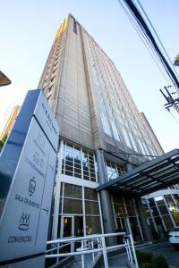 a tall building with a sign in front of it at Flat Executivo GRU Airport in Guarulhos