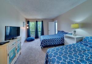 a bedroom with two beds and a flat screen tv at Siesta Key Beach - 2 Bedroom - 3 Beds - 3 Bathroom Duplex with Heated Swimming Pool in Siesta Key +60 photos