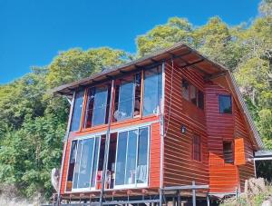 a wooden house with large windows on a hill at El Amado in General Alvear