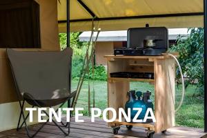 a tent with a stove and a chair on a porch at Camping Onlycamp Les Deux Rives in Lannion +33 photos