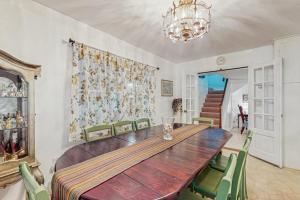 a dining room with a wooden table and green chairs at The CAVU Mansion on Bellevue in Oklahoma Heights