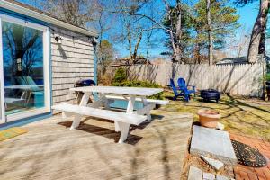 a picnic table on a patio next to a house at Calm Waters in Bourne