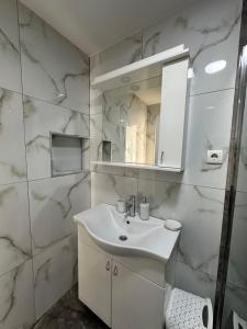 a white bathroom with a sink and a mirror at Prestige in Arandelovac +16 photos
