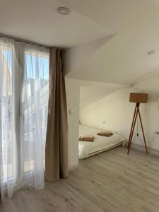 a bedroom with a bed and a large window at Prestige in Arandelovac