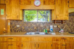a kitchen with a sink and a clock on a window at Grandma's Sandbox in Beulah