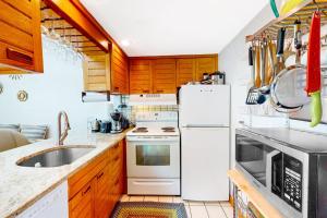 a kitchen with wooden cabinets and a white refrigerator at Riviera Sunset in Chatham