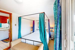 a bedroom with a canopy bed with blue curtains at Riviera Sunset in Chatham
