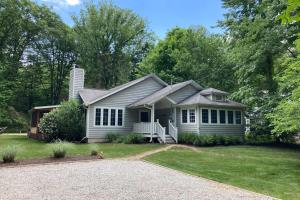 a white house with a porch and a driveway at Ravenswood Pool House in Sawyer