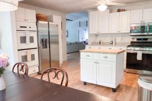 a kitchen with white cabinets and a table and chairs at Ravenswood Pool House in Sawyer