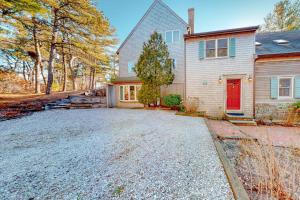 a house with a red door and a driveway at Tranquil Getaway in Wellfleet