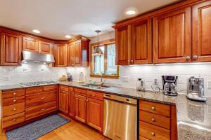 a kitchen with wooden cabinets and stainless steel appliances at Tranquil Getaway in Wellfleet