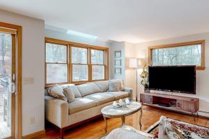 a living room with a couch and a flat screen tv at Tranquil Getaway in Wellfleet +43 photos