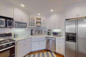 a kitchen with white cabinets and stainless steel appliances at Cotuit Mannor in Cotuit +38 photos