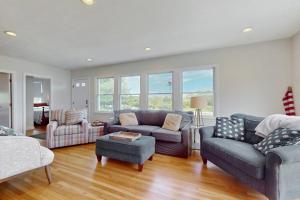 a living room with a couch and a chair at Harbor Point Cottage in Bourne