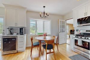 a kitchen with a table and chairs and a stove at Harbor Point Cottage in Bourne