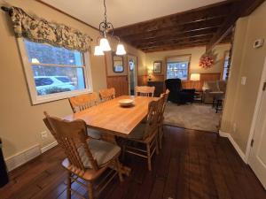 a dining room with a wooden table and chairs at Saltbox in Thompsonville
