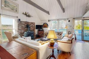 a living room with white furniture and a fireplace at Soundmeadow House in Oak Bluffs