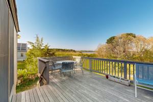 a patio with a table and chairs on a deck at Soundmeadow House in Oak Bluffs