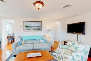 a living room with a couch and a table at Cataumet Cottage in Bourne