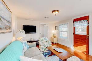 a living room with a couch and a table at Cataumet Cottage in Bourne