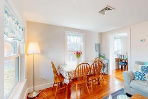 a dining room with a table and chairs and a couch at Cataumet Cottage in Bourne