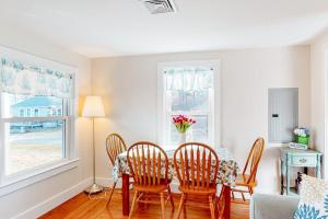 a dining room with a table and four chairs at Cataumet Cottage in Bourne +21 photos