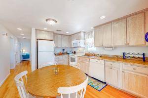 a kitchen with a wooden table and white appliances at Cape Estate 6 in South Dennis