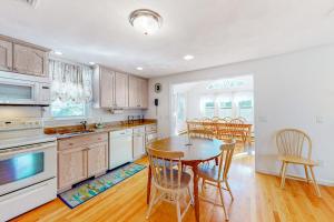 a kitchen with a table and chairs in a room at Cape Estate 6 in South Dennis