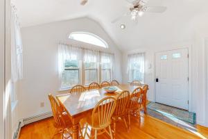 a dining room with a wooden table and chairs at Cape Estate 6 in South Dennis +22 photos