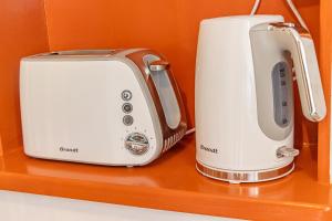two toasters and a toaster on a shelf at Studio Le Cosy Jungle & Piscine in Pointe-à-Pitre