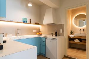 a kitchen with blue cabinets and a sink at Olea Blue in Skiathos +31 photos