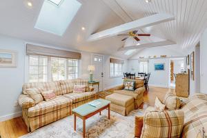 a living room with couches and a ceiling fan at Seaside Park Retreat in West Hyannisport