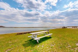 a picnic table sitting on the grass near the water at Seaside Park Retreat in West Hyannisport