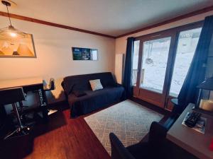 a living room with a couch and a window at Le Nid du Sancy - Les Matins du Sancy - Super-Besse in Super Besse