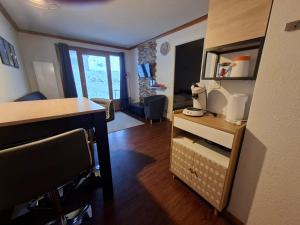 a room with a desk and a living room at Le Nid du Sancy - Les Matins du Sancy - Super-Besse in Super Besse