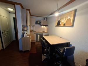 a kitchen with a table and chairs in a room at Le Nid du Sancy - Les Matins du Sancy - Super-Besse in Super Besse +4 photos