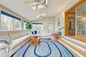 a living room with a white couch and a blue rug at Wharf Side Hideout in Hyannis