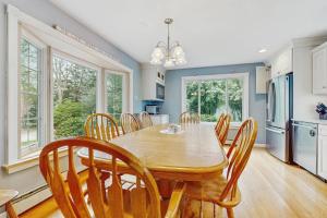 a dining room with a wooden table and chairs at Wharf Side Hideout in Hyannis