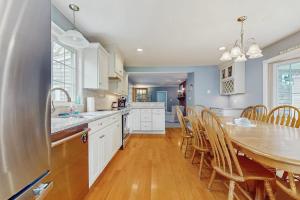a kitchen with a table and chairs and a dining room at Wharf Side Hideout in Hyannis +19 photos