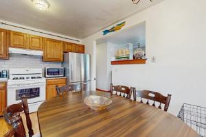 a kitchen with a wooden table and a refrigerator at Hyannis Beach House in Hyannis