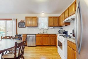 a kitchen with wooden cabinets and a white refrigerator at Hyannis Beach House in Hyannis +15 photos
