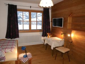 ein Wohnzimmer mit einem Tisch und einem Fenster in der Unterkunft Lindenhof in Kitzbühel