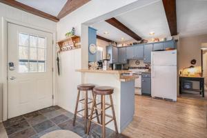 a kitchen with a refrigerator and two bar stools at Johnson Cottage in Glenn
