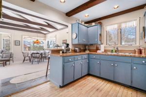 a kitchen with blue cabinets and a dining room at Johnson Cottage in Glenn +17 photos