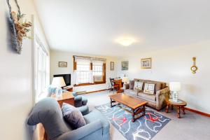 a living room with a couch and a table at Nauset Beach Buddy in Orleans