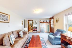 a living room with a couch and a table at Nauset Beach Buddy in Orleans