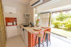 a small kitchen with a counter and stools in it at Studio Le Cosy Jungle & Piscine in Pointe-à-Pitre